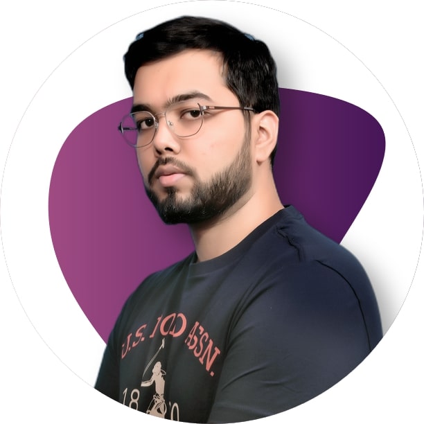 Ramit Surana smiling in a red plaid shirt and tortoise shell glasses